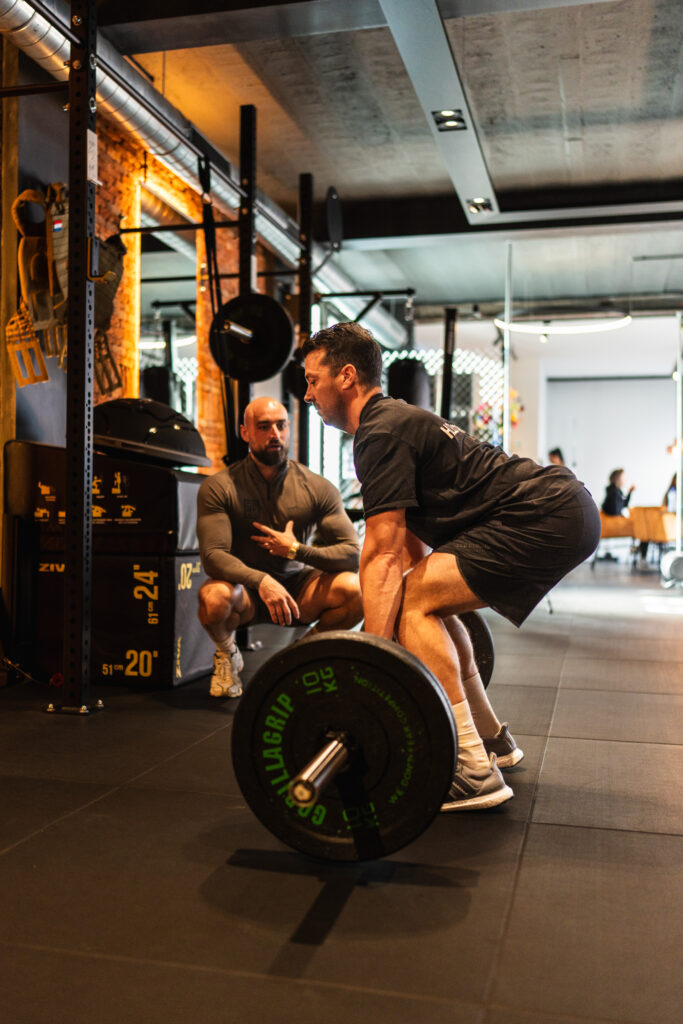 Personal trainer begeleid klant tijdens het sporten